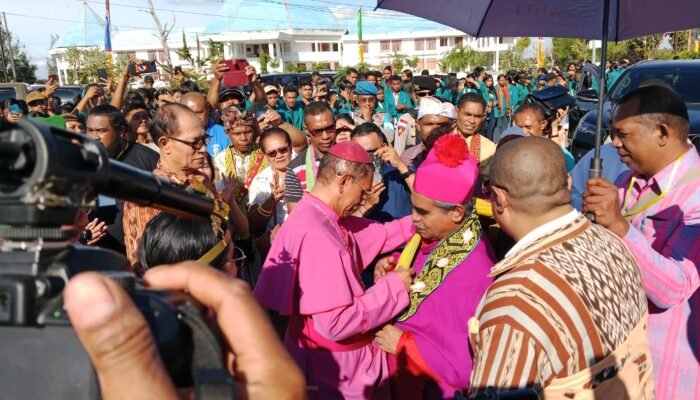 Uskup Atambua Mgr. Dominikua Saku, Pr, saat memberikan pengalungan selendang kepada Uskup Agung Kupang, Mgr. Hironimus Pakaenoni, Pr. (Foto: BN) 